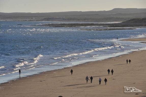 Pessoas caminham na praia de Las Grutas, na Argentina